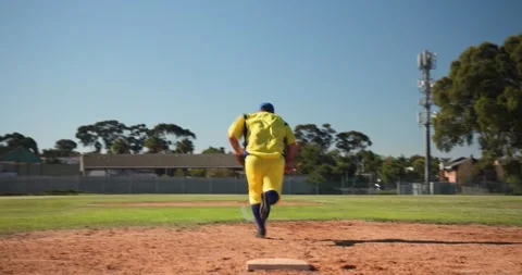 On throw first baseman in yellow is tagging sliding runner at base on diamond Stock Footage 338434078
