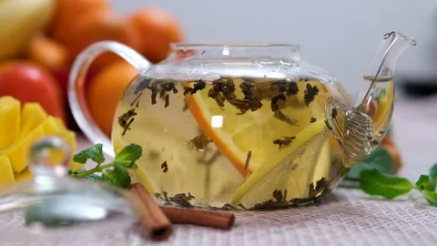 Throw an orange slice into the tea Putting Mint Leaves Into Berry Tea With Video stock 310936907