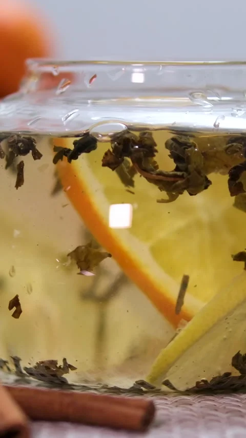 Throw an orange slice into the tea Putting Mint Leaves Into Berry Tea With Video stock 313392197