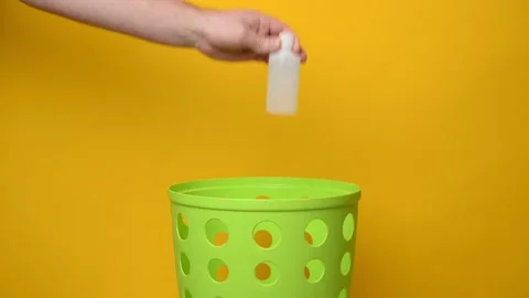 Throw a white plastic bottle with liquid into a green trash can. Stock Footage 194566395