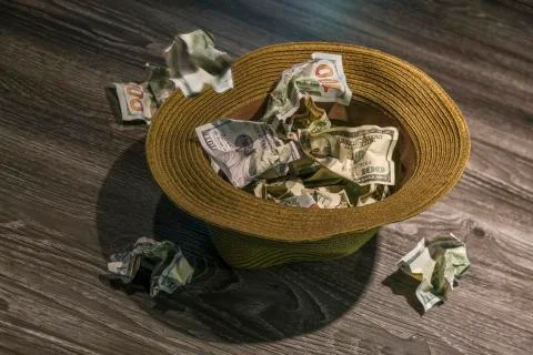Throwing $100 bills into hat Stock Photos