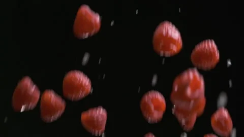 Throwing up and falling down raspberries and drops of water on the black Stock Footage 170416762