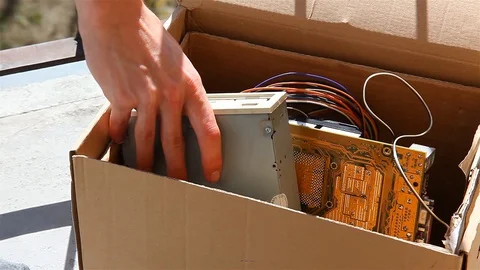 Throwing away electronic waste, man putting old pc parts in a box taking it away Stock Footage 129427174