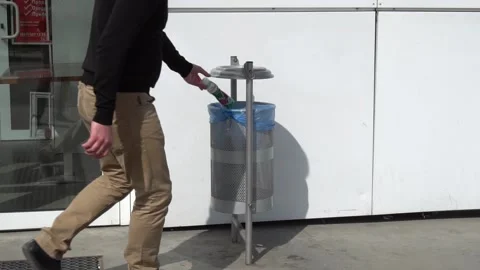 Throwing away garbage in public trash can Stock Footage 89595114