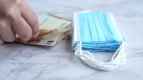 Throwing bills on the table for all the money spent on masks during the pande Stock Footage 146546390