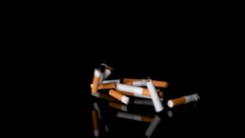 Throwing cigarettes stubs on black reflective background from the right side. Stock Footage 147527509