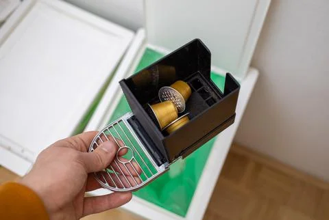 Throwing coffee capsules in the trash bin Stock Photos