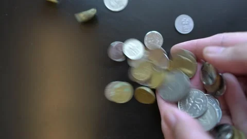 Throwing coins on a black surface Stock Footage 147475748
