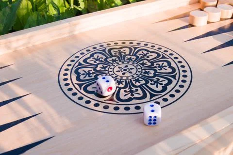 Throwing dice in backgammon board game close up, selective focus Stock Photos