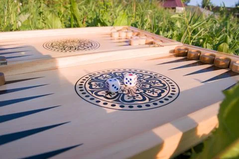Throwing dice in backgammon board game close up. Foreground soft focus Stock Photos