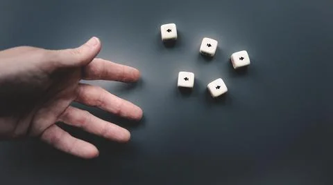 Throwing the dice on a dark grey background. Stock Photos