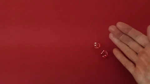 Throwing the dice. Red cubes with white dots on red background Stock Footage 326243202