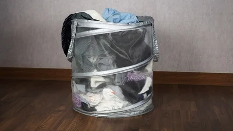 Throwing dirty clothes to the basket until full Stock Footage 89662348