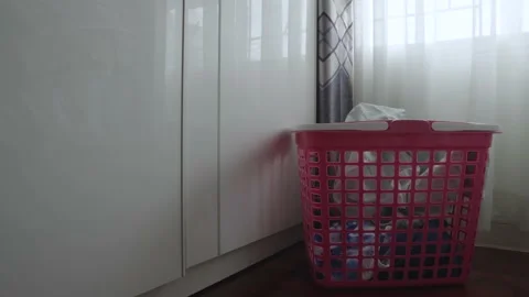 Throwing dirty clothes to the basket until full. Stock Footage 237003165