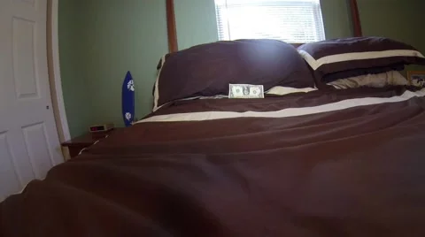 Throwing down a dollar bill on a bed 스톡 동영상 47653217