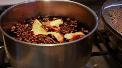 Throwing dried fruit into pot of mulled wine closeup. Mulled wine making process Stock Footage 239435854