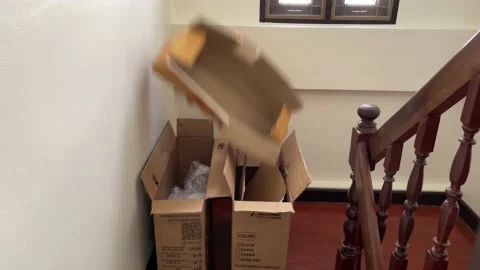 Throwing empty cardboard box down wooden stairs at home with white wall 库存影片 205884029