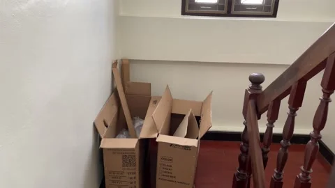 Throwing empty cardboard box down wooden stairs at home with white wall Stock Footage 205884066