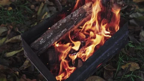 Throwing firewood into a burning fire in the grill in slow motion Stock Footage 143387632