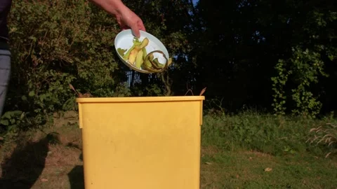 Throwing food scraps waste into compost bin Stock Footage 339707995