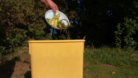 Throwing food scraps waste into compost bin Stock Footage 340840970