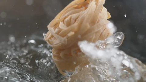 Throwing fresh linguine noodle in boiling water. Slow Motion. Stock Footage 94091572