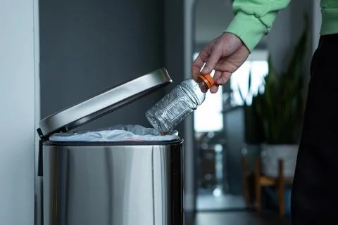Throwing a garbage into a large stainless steel bin at home Stock Photos