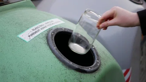 Throwing glass jars into a recycling container closeup Stock-Footage 107561078