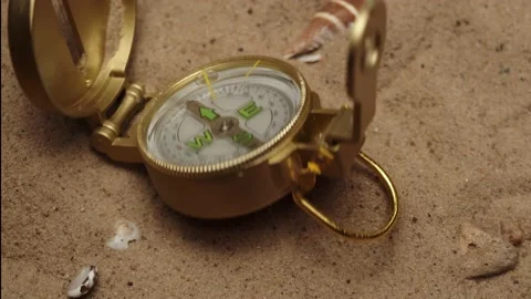 Throwing gold compass on sand background close-up, golden compass. Traveling and Stock Footage 158930363