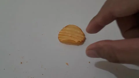 Throwing Golden Crispy Potato Chip Across the Table Stock Footage 337785923