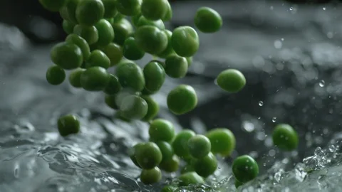 Throwing green peas into boiling water. Slow Motion. Stock Footage 94087356