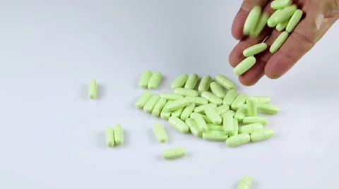 Throwing green pills on the table Видео 41853677