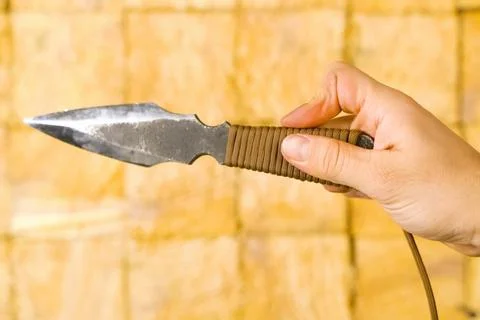 Throwing knife in hand aiming at target. Stock Photos