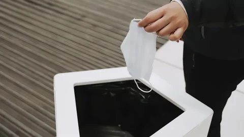 Throwing medical mask in garbage bin, trash. Problem of sorting, recycling Stock Footage 130911297