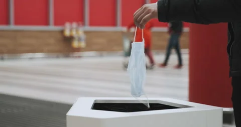 Throwing medical mask in garbage bin, trash. Problem of sorting, recycling Stock Footage 130911311