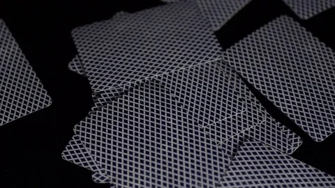 Throwing, or giving, playing cards on a black reflective surface Stock Footage 79040641