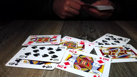 Throwing, or giving, playing cards on a wooden surface Stock Footage 223562383