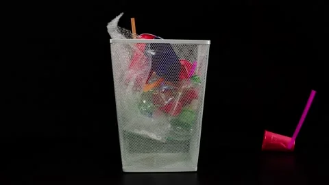 Throwing plastic garbage in the empty metal trash can on black background Stock Footage 156670240