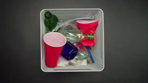 Throwing plastic garbage in the metal trash can on black background. Glasses Stock Footage 156670401