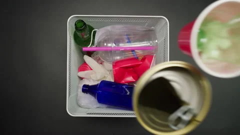 Throwing plastic garbage in the metal trash can on black background top view Stock Footage 156821857