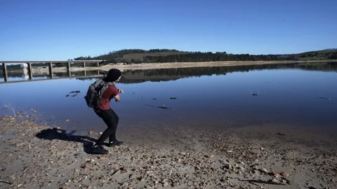 Throwing rocks on the lake Stock Footage 98534085