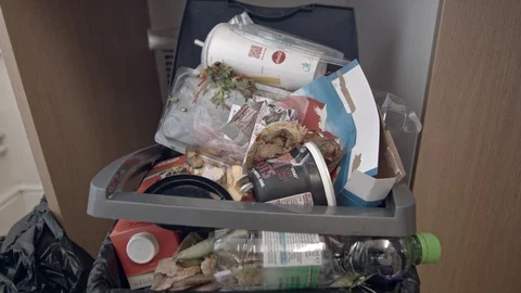 Throwing rubbish into a kitchen bin with recyclable and non recyclable items Stock Footage 85823738