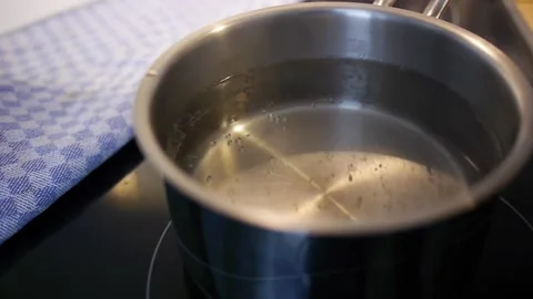 Throwing sea slat to boiling water in a stainless steel bowl Stock Footage 147406280