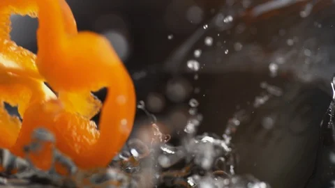 Throwing sliced orange bell pepper into water. Slow Motion. Stock Footage 94083377