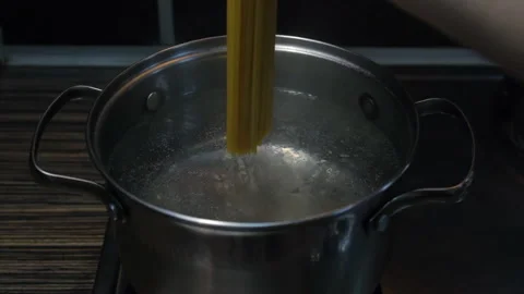Throwing spaghetti pasta into water Stock Footage 196430306
