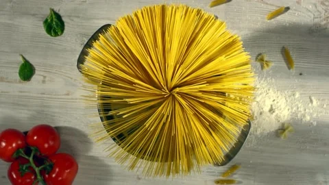 Throwing spaghetti pasta into water. Overhead shot. Top view. Shot with cinema Stock Footage 130232897