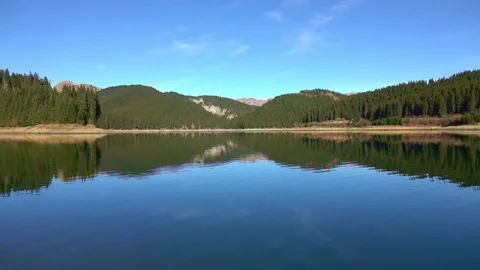 Throwing stones in the mountain lake Stock Footage 97866494