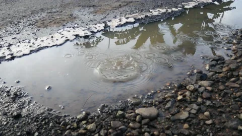 Throwing stones into puddles by the roadside. Stock Footage 206325478