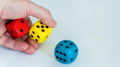 Throwing three dice of blue, red and yellow color. Stock Photos