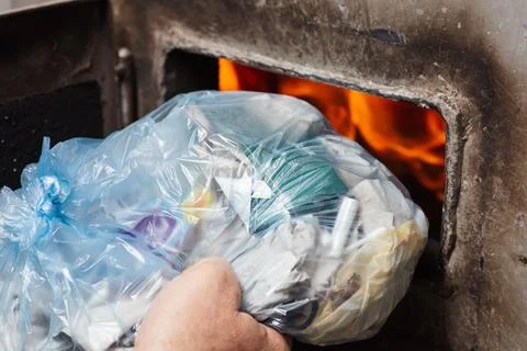 Throwing the trash into solid fuel boiler, close up Stock Photos